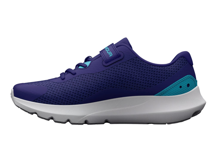 Tenis deportivos Under Armour color azul con detalles en turquesa, suela blanca y cierre de correa con velcro.