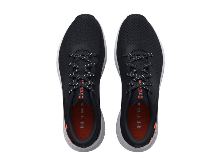 Tenis deportivos Under Armour color negro con suela blanca y logotipo rojo en el costado.