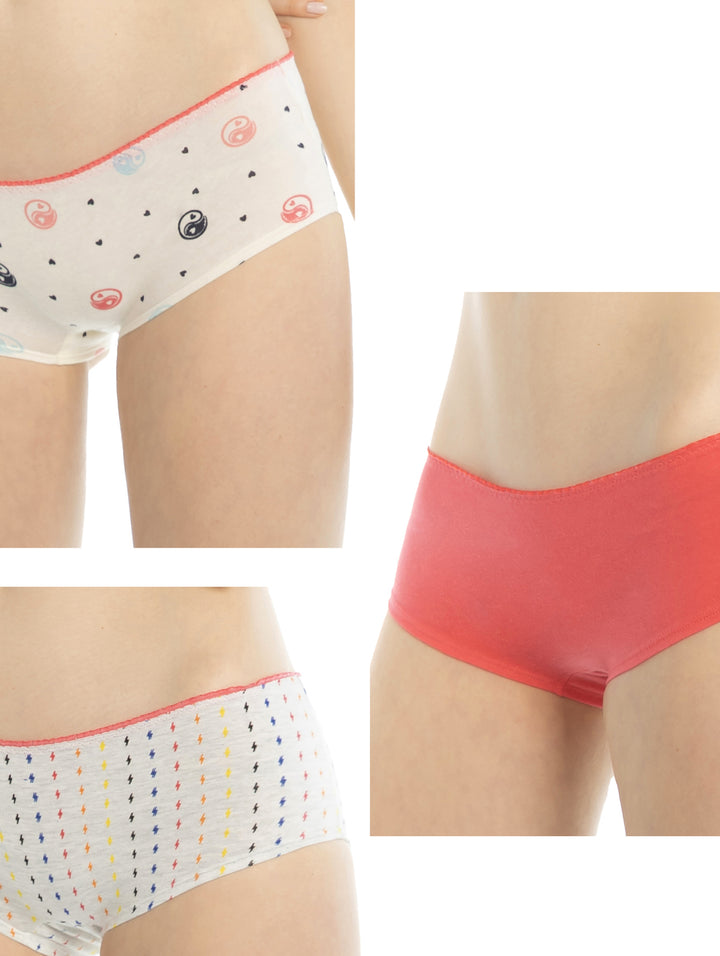 Set de tres boxers para mujer: uno coral sólido y dos blancos con estampados de rayos y yin-yang.