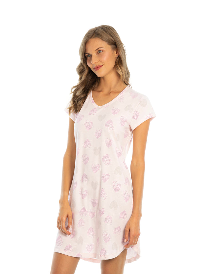 Mujer vistiendo un camisón rosa claro con estampado de corazones y cuello en V.