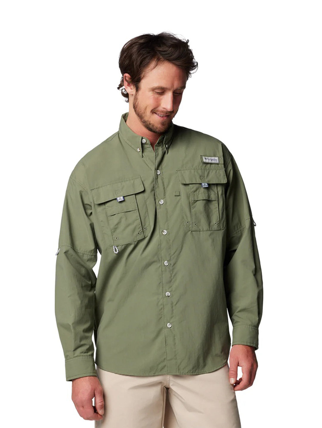 Hombre vistiendo una camisa Columbia de manga larga en color verde cypress con bolsillos frontales.