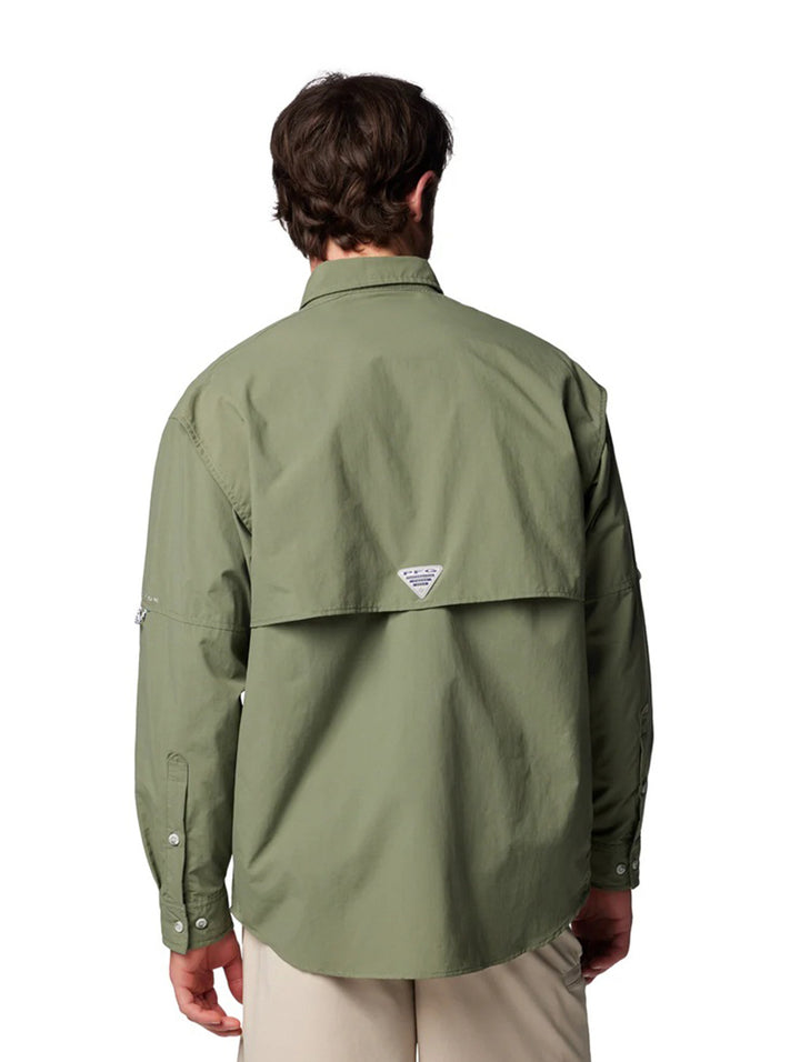 Hombre vistiendo una camisa Columbia de manga larga en color verde cypress con bolsillos frontales.