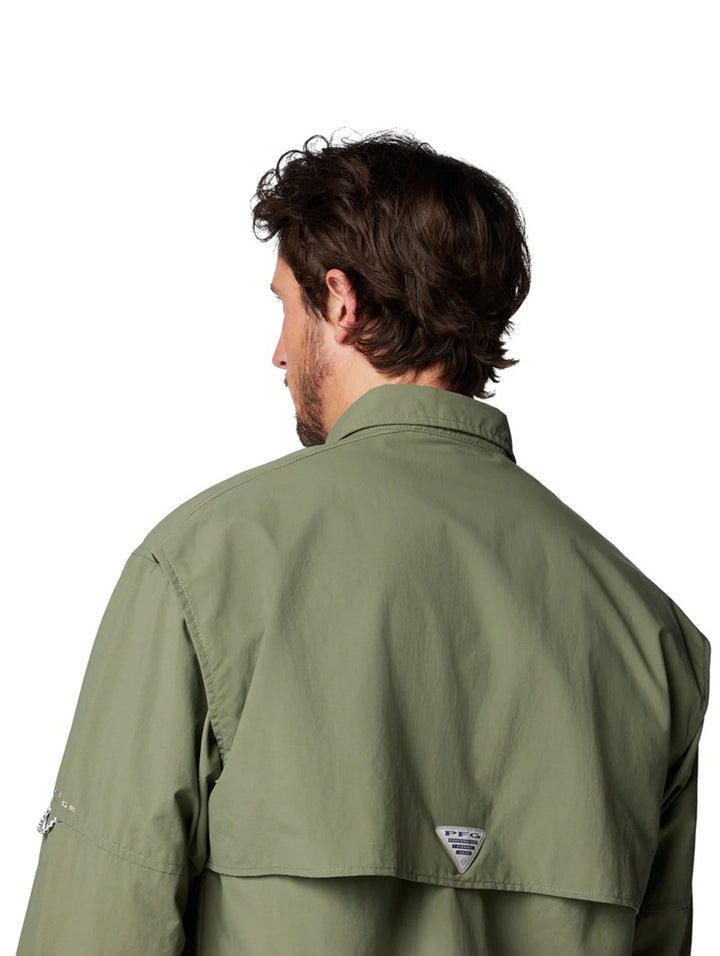 Hombre vistiendo una camisa Columbia de manga larga en color verde cypress con bolsillos frontales.