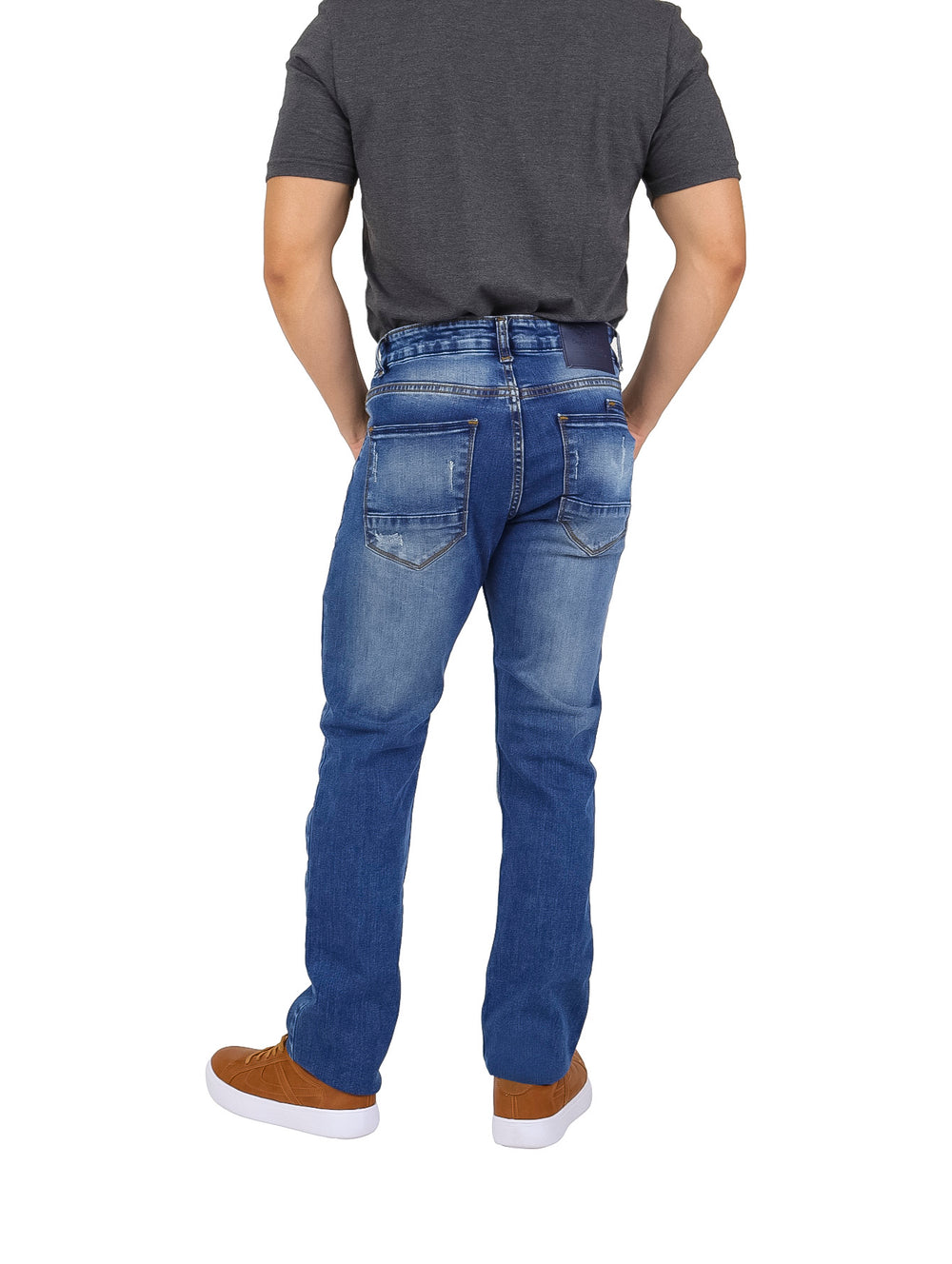 Hombre vistiendo pantalones jeans slim color azul con detalles de destrucción y desgaste.