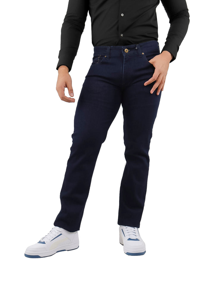 Hombre vistiendo pantalones jeans slim fit color azul petróleo, camisa negra y tenis blancos.