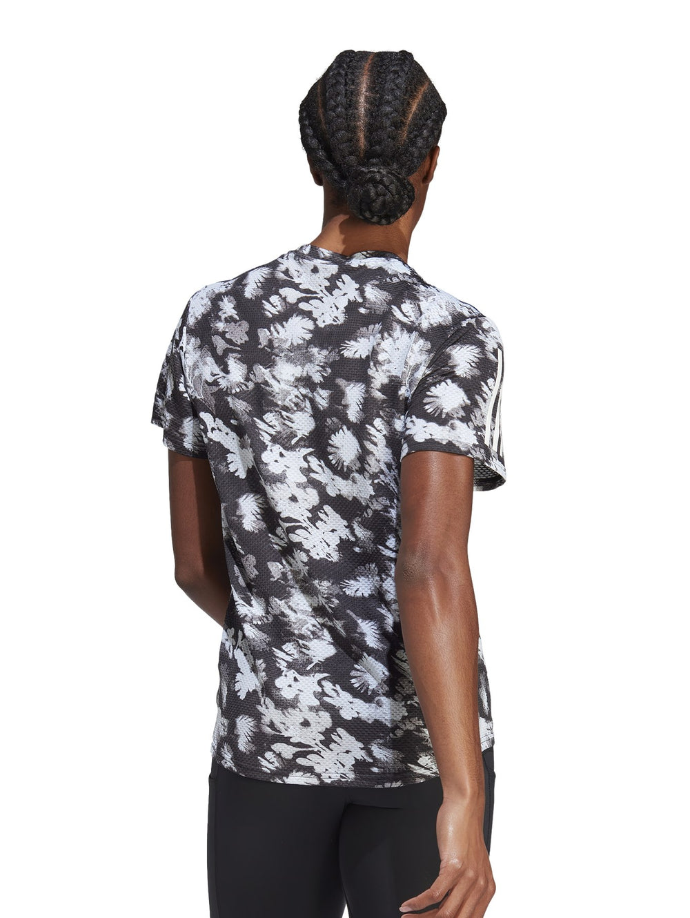 Camiseta deportiva Adidas de manga corta con estampado abstracto en gris y negro y rayas blancas en los hombros.