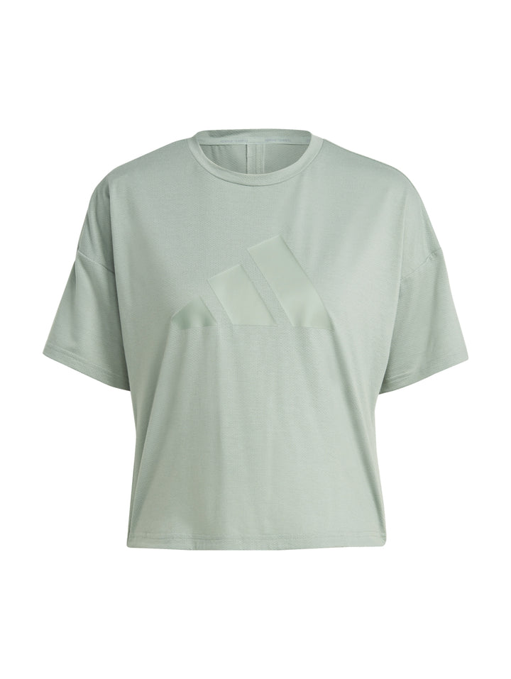 Mujer vistiendo una playera Adidas de color verde silver green con diseño de tres franjas tonales en el pecho.