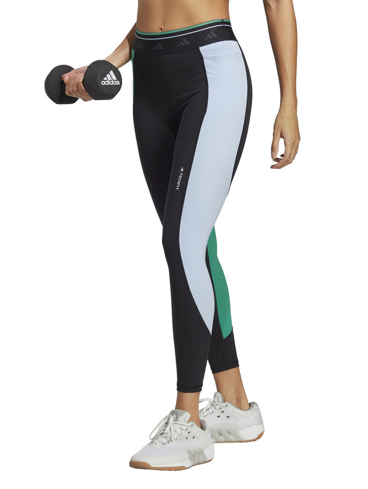 Leggings deportivos Adidas color negro con panel lateral blanco y detalle verde, corte 7/8.