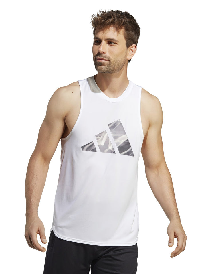 Hombre vistiendo una camiseta deportiva sin mangas color blanco de la marca Adidas con gráfico frontal.