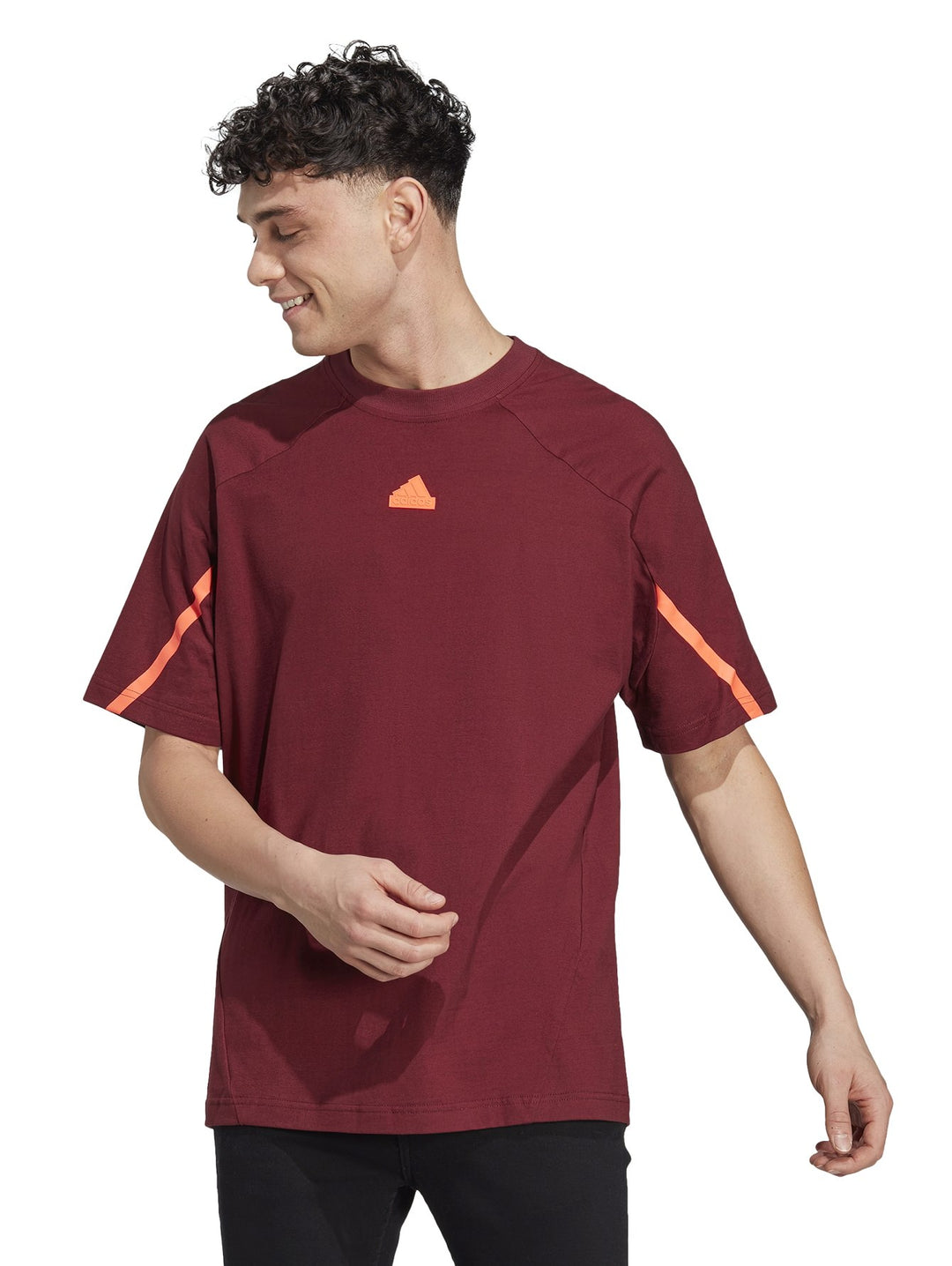 Hombre vistiendo playera Adidas color rojo oscuro con detalles naranjas en las mangas.