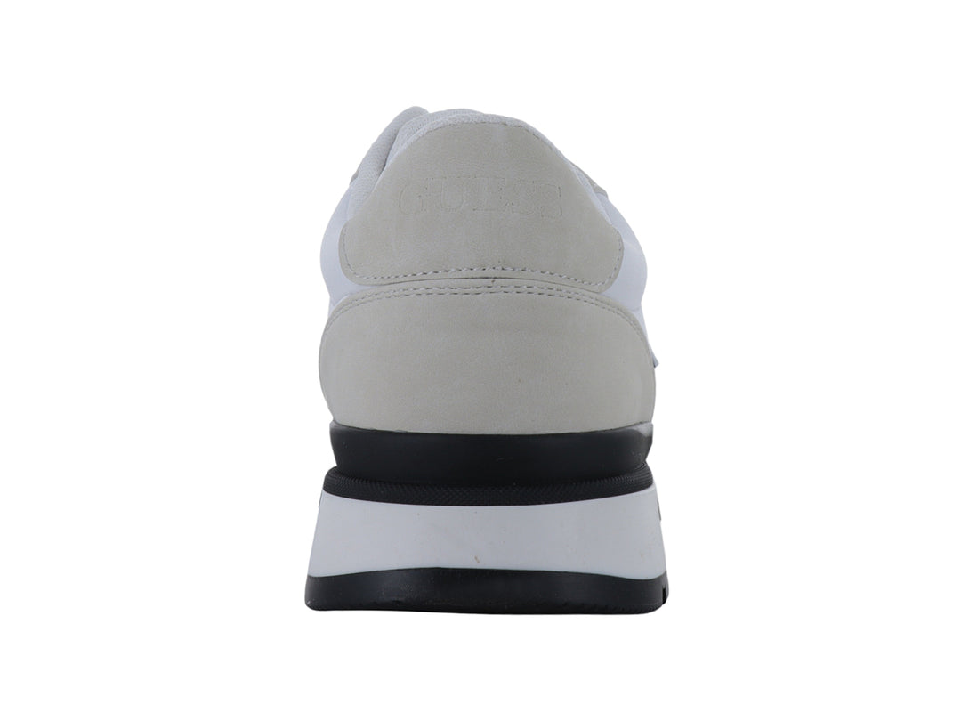 Tenis Guess color blanco y gris con suela negra y logotipo triangular en el lateral.