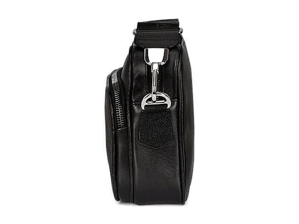Bolso bandolera negro de marca Cuadra con textura de piel de mantarraya y correa ancha.