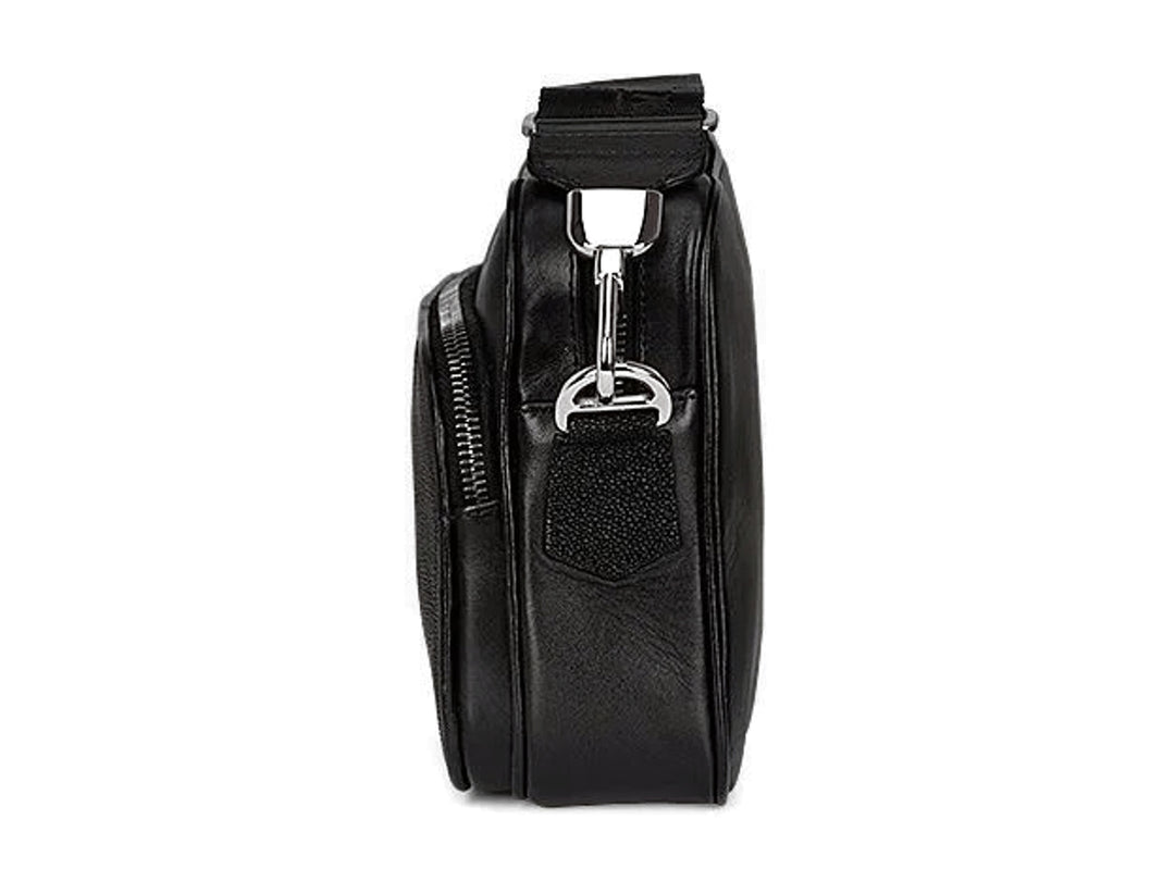 Bolso bandolera negro de marca Cuadra con textura de piel de mantarraya y correa ancha.