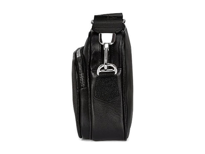 Bolso bandolera negro de marca Cuadra con textura de piel de mantarraya y correa ancha.