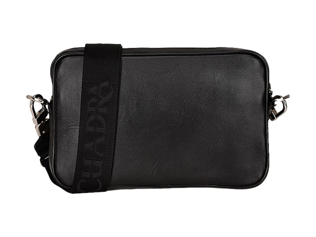 Bolso bandolera negro de marca Cuadra con textura de piel de mantarraya y correa ancha.