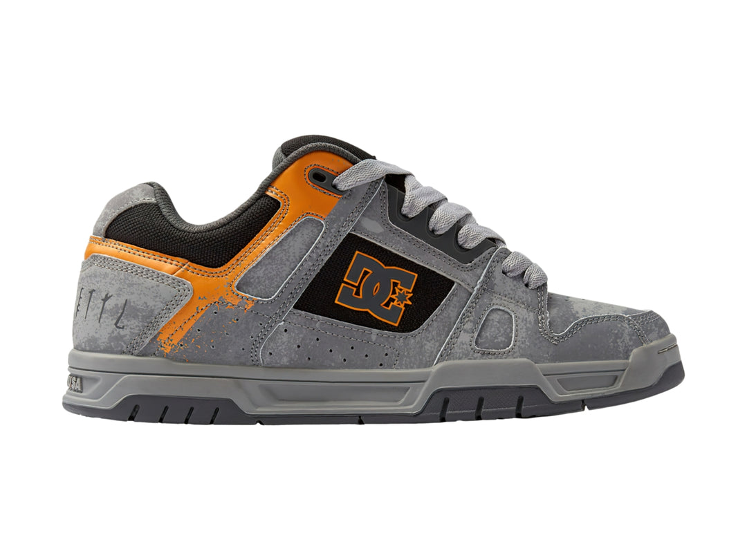 Tenis DC Shoes SW Stag color gris con detalles en naranja y negro, vista lateral.