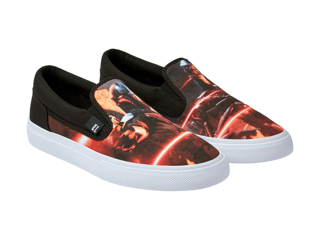 Tenis DC Shoes modelo slip-on en color negro y rojo con estampado gráfico y suela blanca.