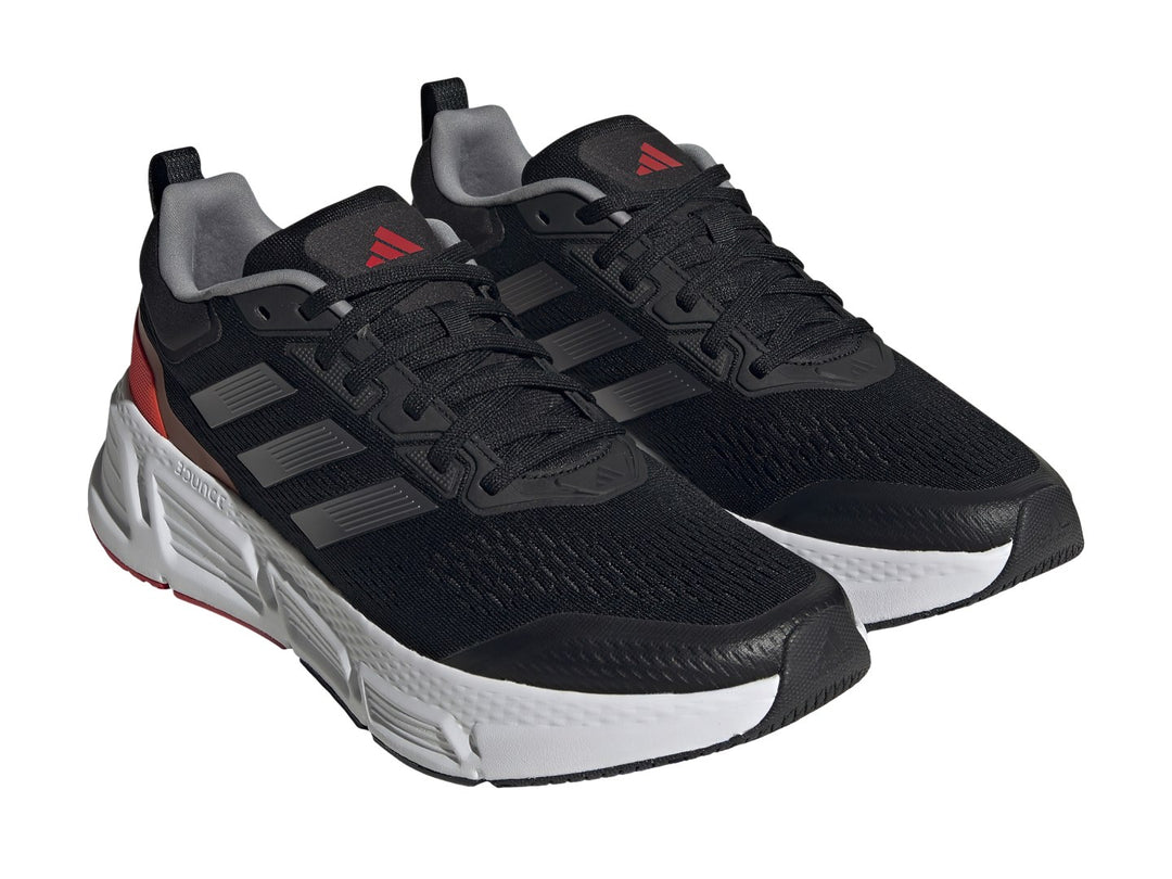 Tenis deportivos Adidas Questar color negro con suela blanca y detalles en gris metálico y rojo.