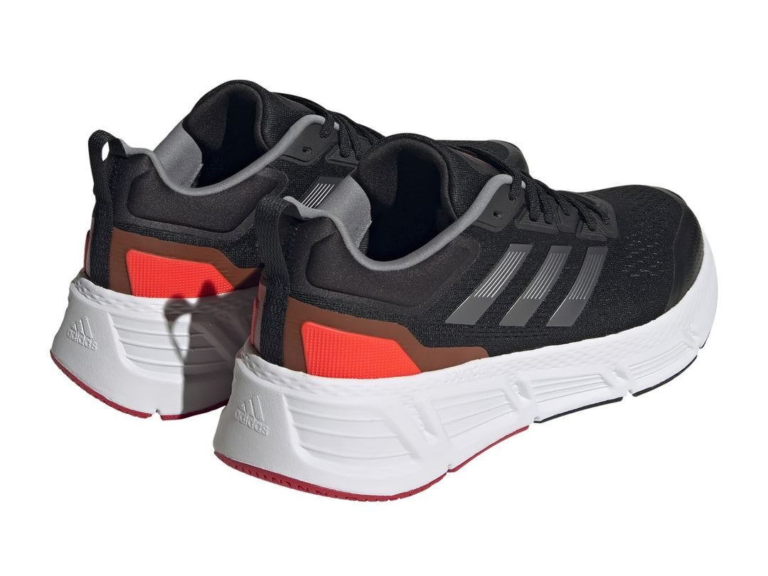 Tenis deportivos Adidas Questar color negro con suela blanca y detalles en gris metálico y rojo.