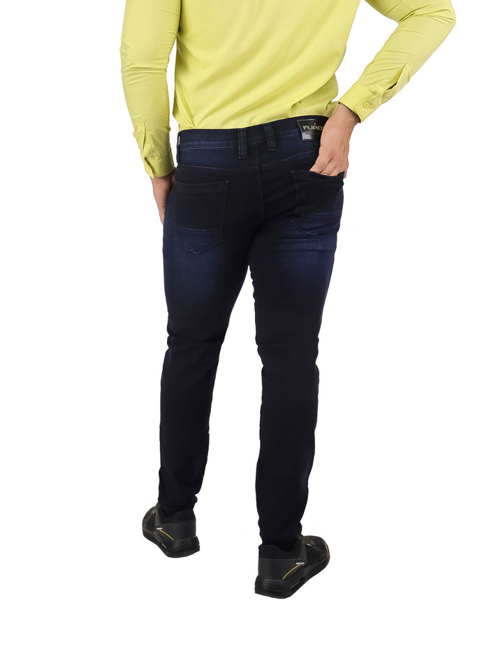 Hombre vistiendo pantalones jeans ajustados en color azul marino y camisa amarilla.