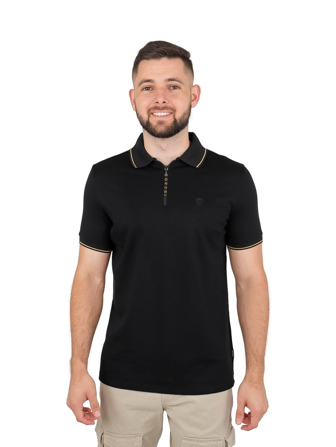 Hombre vistiendo playera polo negra con cierre y detalles en color oro en el cuello y bordes de las mangas.