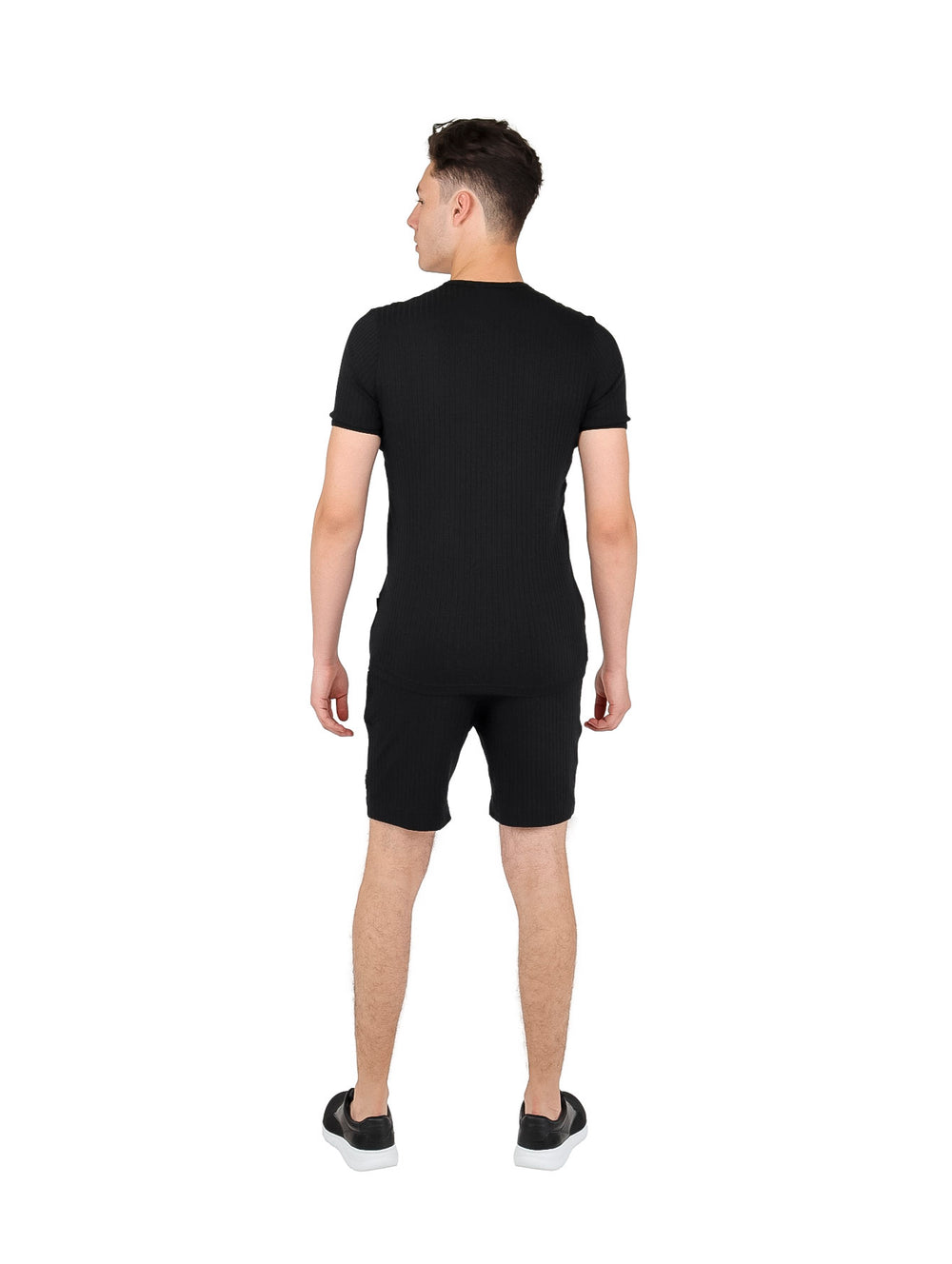 Hombre vistiendo conjunto de playera de manga corta y short en color negro.