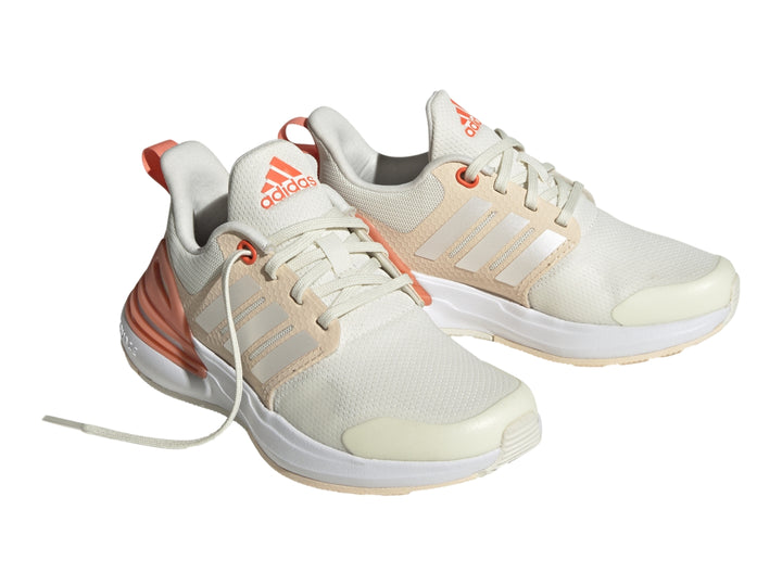 Tenis Adidas Rapidasport color blanco hueso con detalles en naranja y suela blanca.