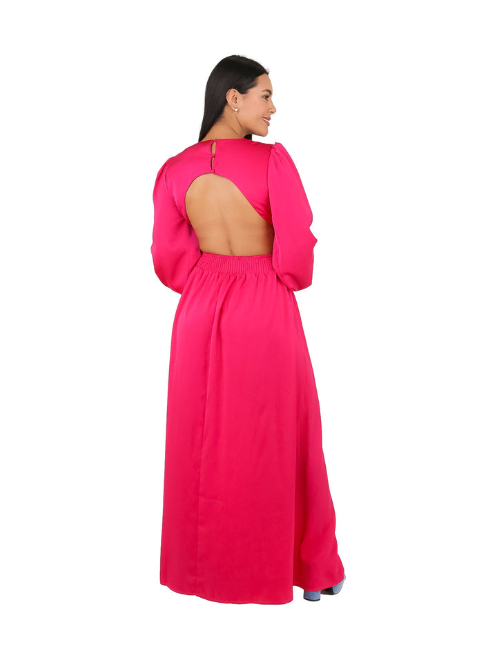 Mujer con vestido maxi rosa de manga larga, escote en V y detalle de anillo en la cintura.