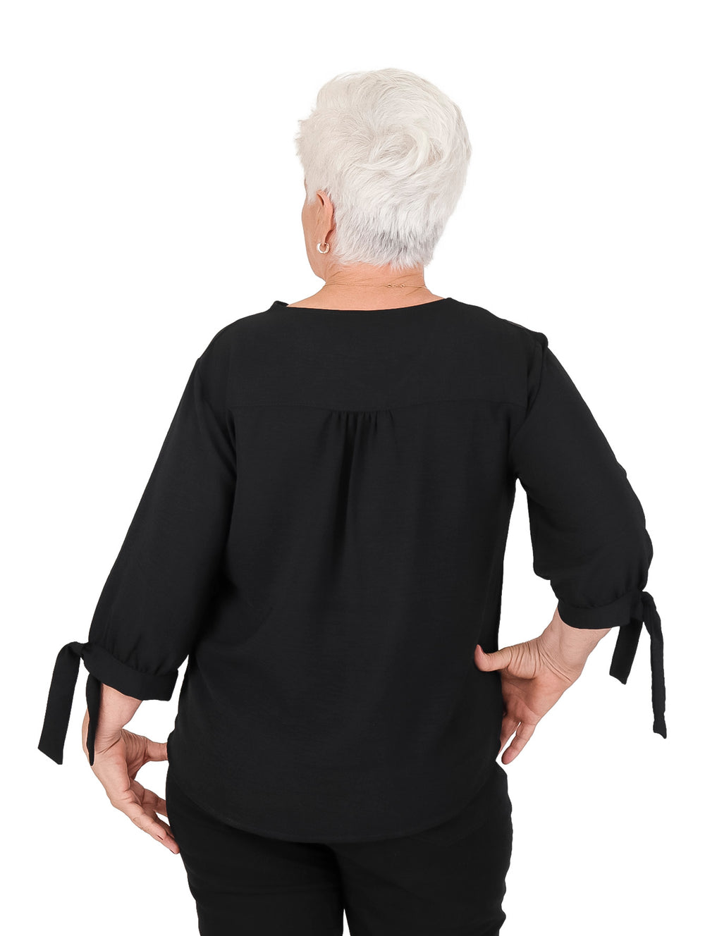 Blusa negra de manga corta con bordados florales en el cuello y moños decorativos en las mangas.