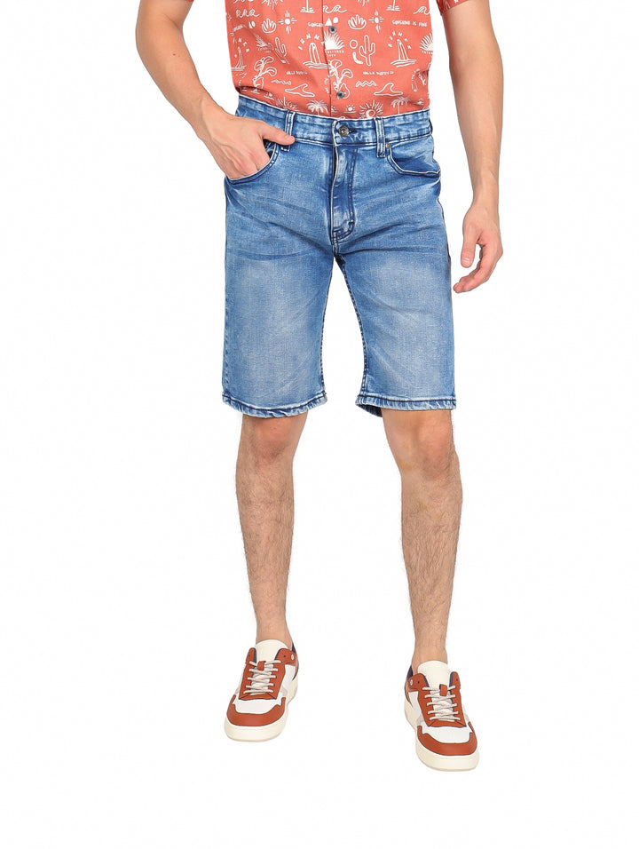 Hombre vistiendo shorts de mezclilla azul claro de corte slim.