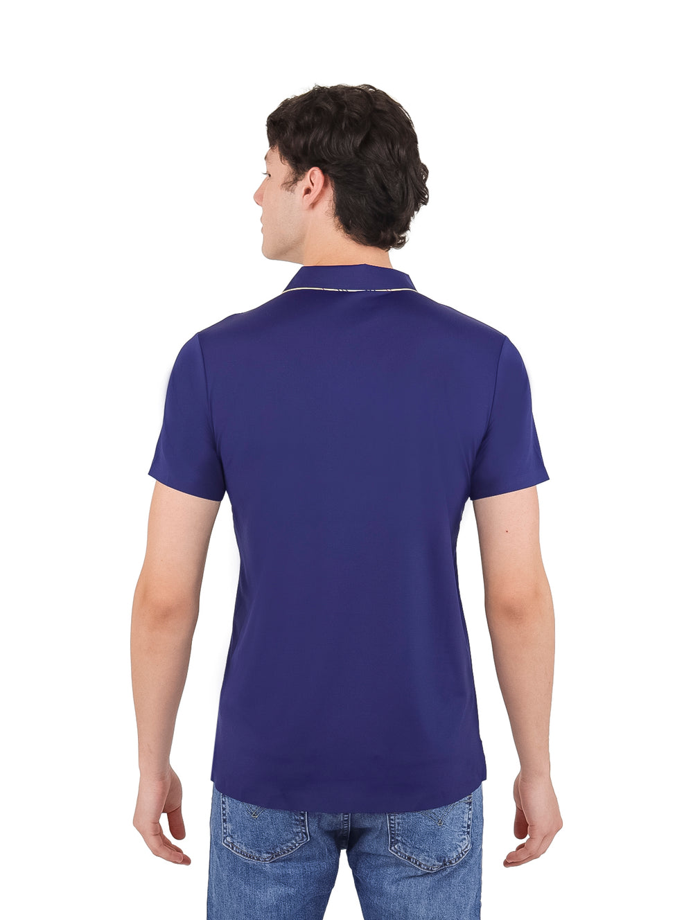 Hombre vistiendo playera polo color azul marino con detalles blancos en el cuello y jeans azules.