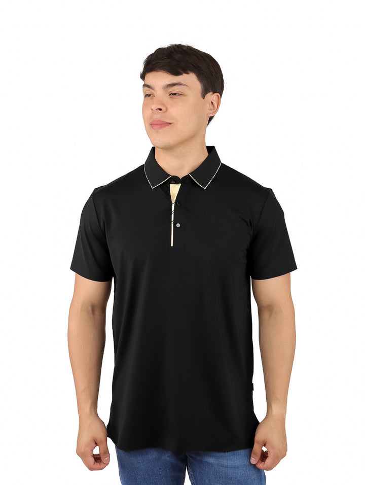 Hombre vistiendo una playera polo color negro con detalles dorados en el cuello y manga corta.