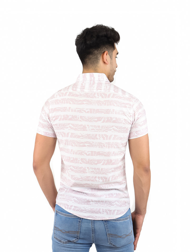 Hombre vistiendo una camisa de manga corta color beige con estampado de hojas.