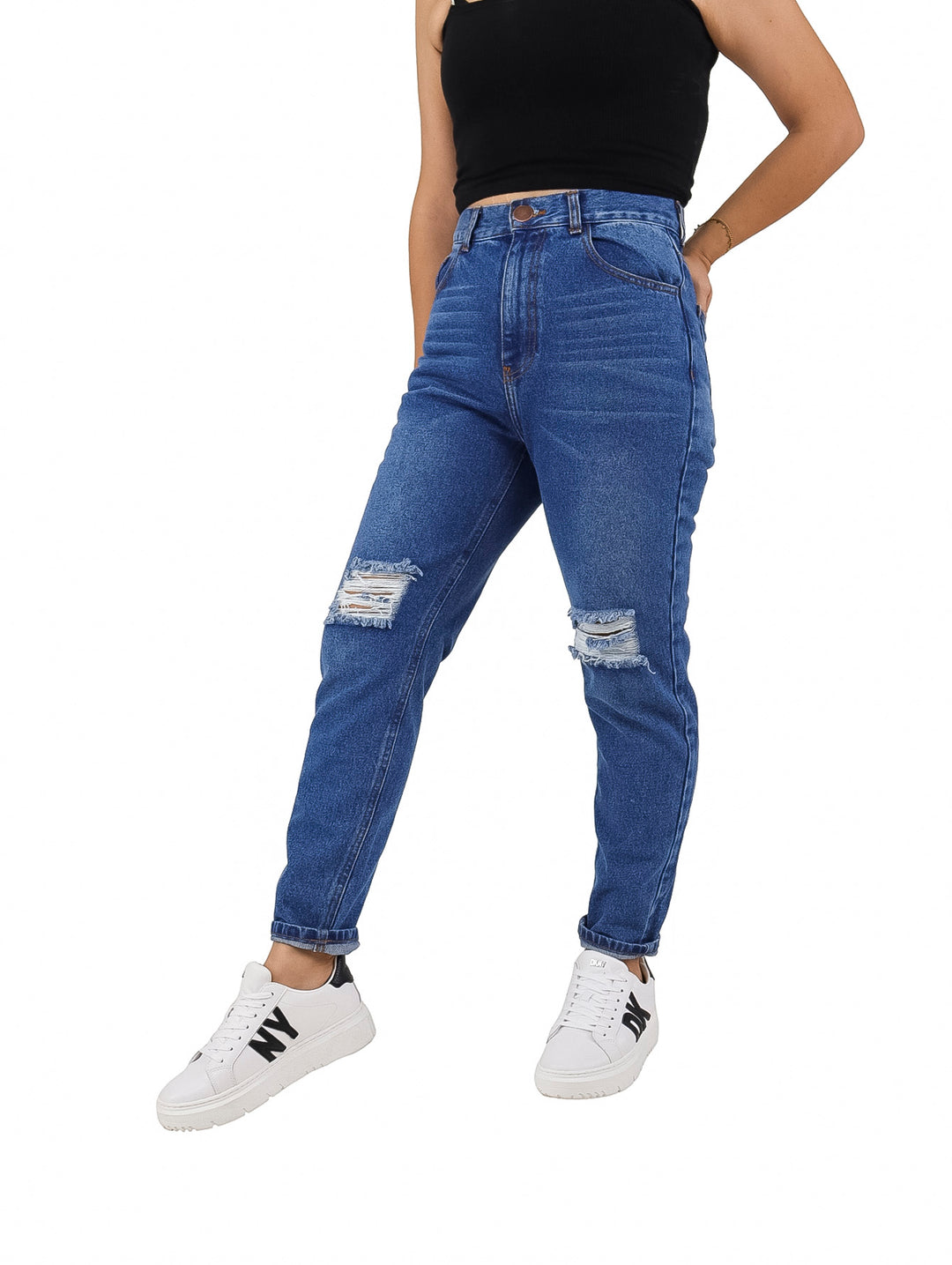 Mujer vistiendo jeans azules de corte recto con roturas en las rodillas y sin bastilla.