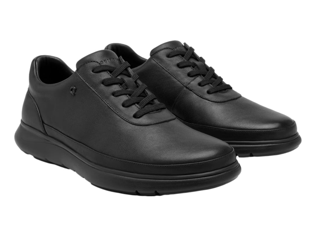 Zapato plano de color negro para hombre con cordones y suela gruesa.