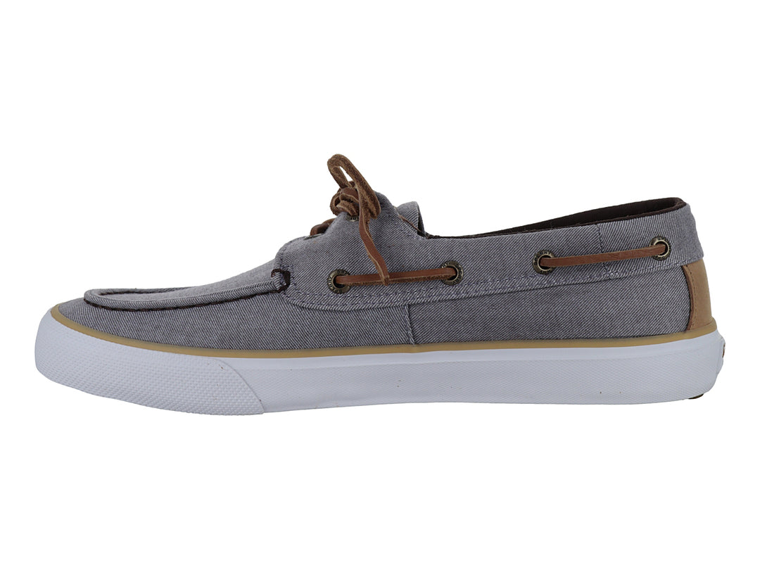 Zapato náutico Sperry de tela gris con cordones cafés y suela blanca.