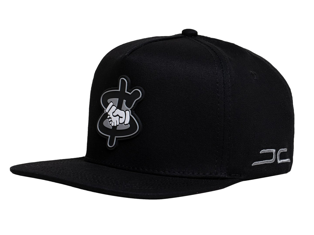 Gorra snapback color negro con visera plana y un parche bordado en el frente que muestra un apretón de manos.