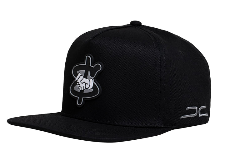 Gorra snapback color negro con visera plana y un parche bordado en el frente que muestra un apretón de manos.