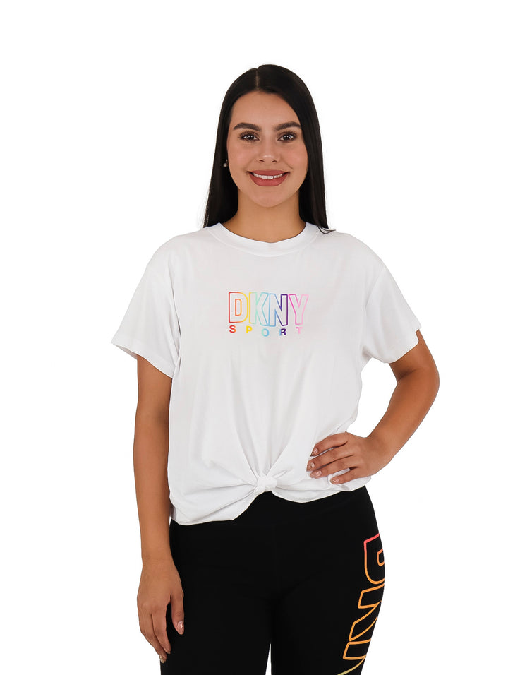 Mujer vistiendo camiseta blanca de manga corta con logotipo colorido de DKNY Sport.