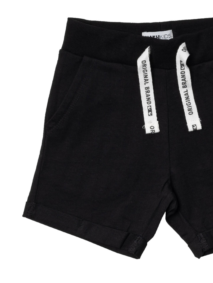 Bermuda color negro para niños con cordones blancos decorativos en la cintura.