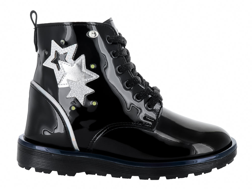 Bota negra de charol brillante con detalle de estrella plateada y agujetas negras.