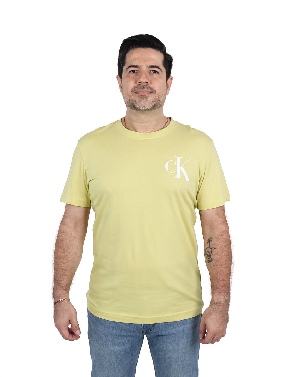 Hombre vistiendo una camiseta de manga corta color oro con logotipo CK blanco en el pecho.