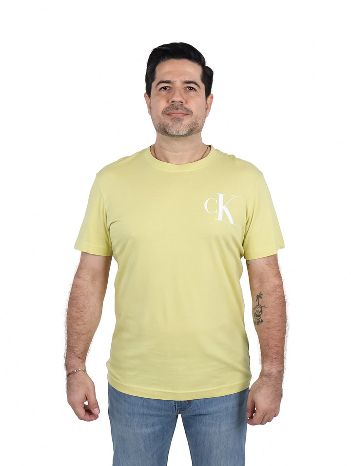 Hombre vistiendo una camiseta de manga corta color oro con logotipo CK blanco en el pecho.