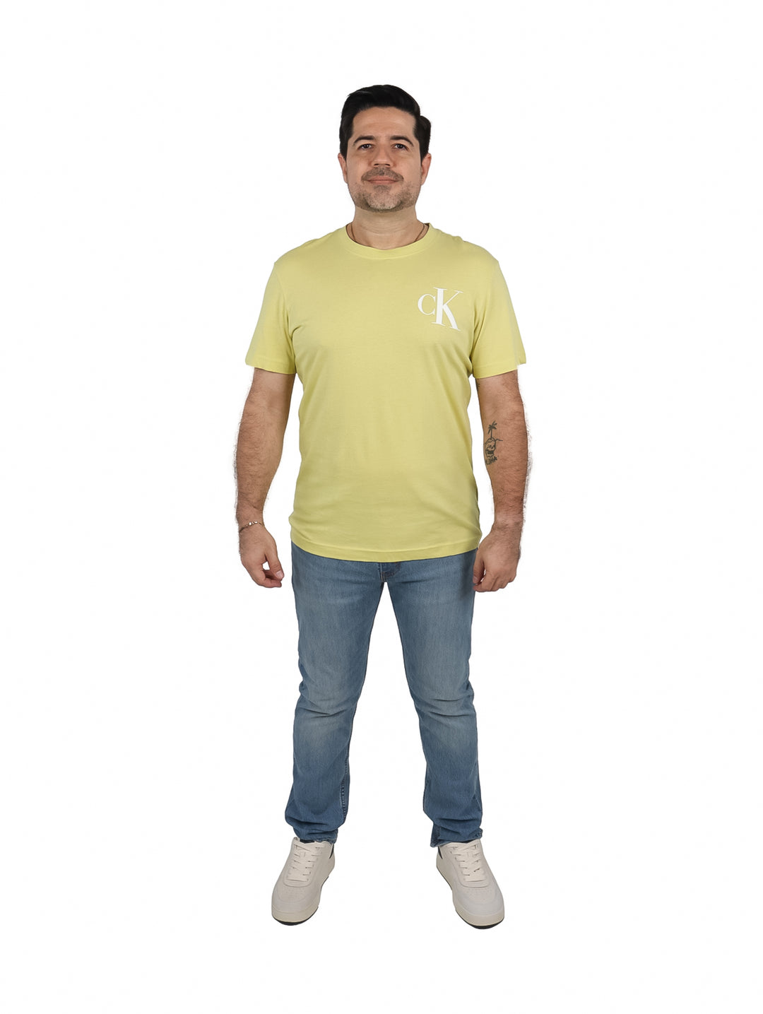 Hombre vistiendo una camiseta de manga corta color oro con logotipo CK blanco en el pecho.