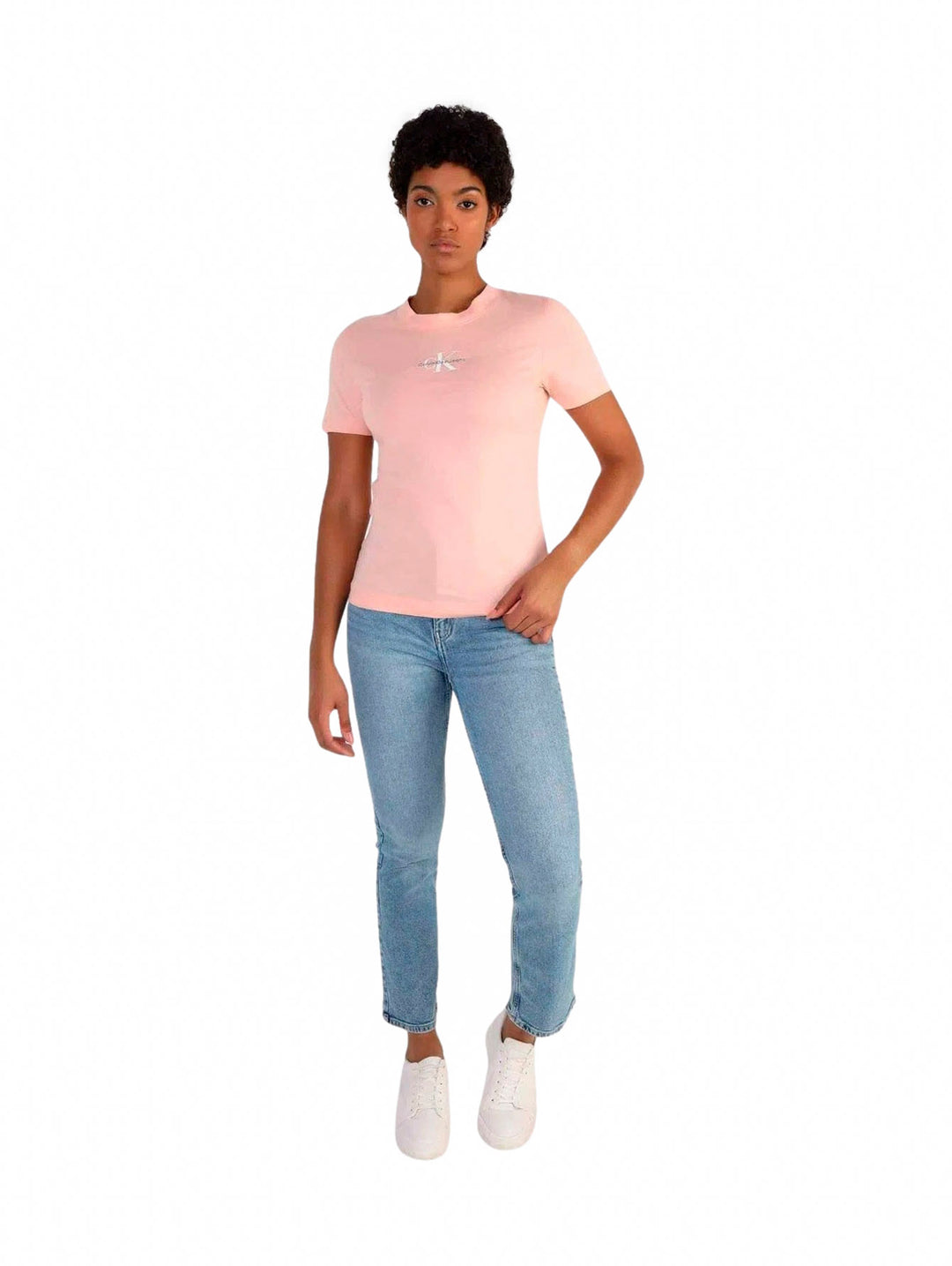 Mujer vistiendo una camiseta rosa slim fit de Calvin Klein y jeans azules.