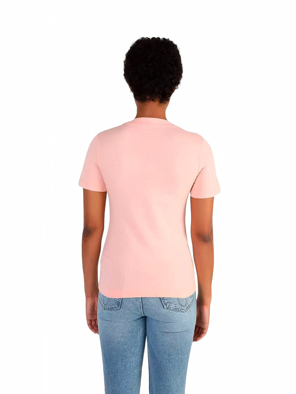 Mujer vistiendo una camiseta rosa slim fit de Calvin Klein y jeans azules.