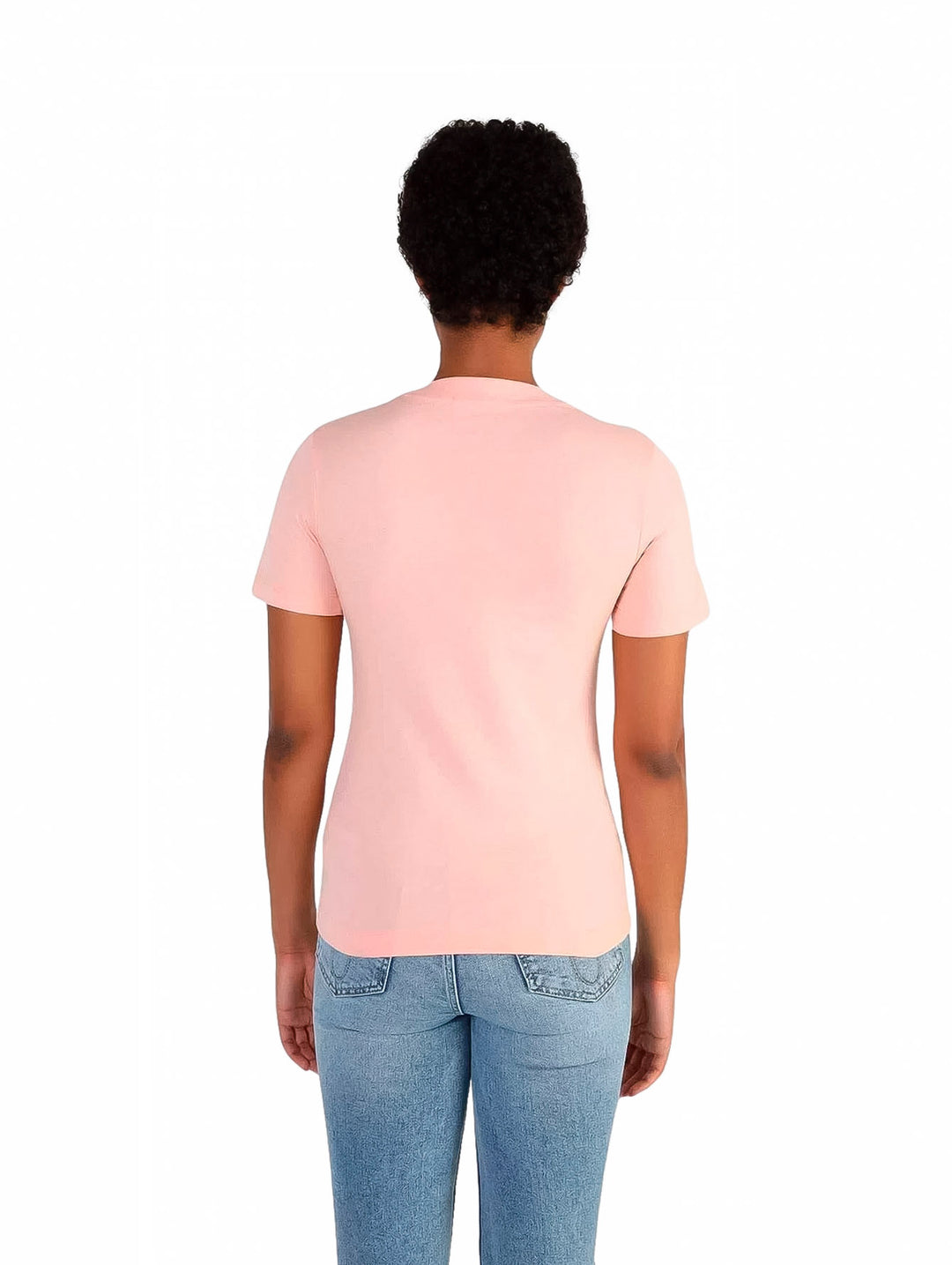 Mujer vistiendo una camiseta rosa slim fit de Calvin Klein y jeans azules.