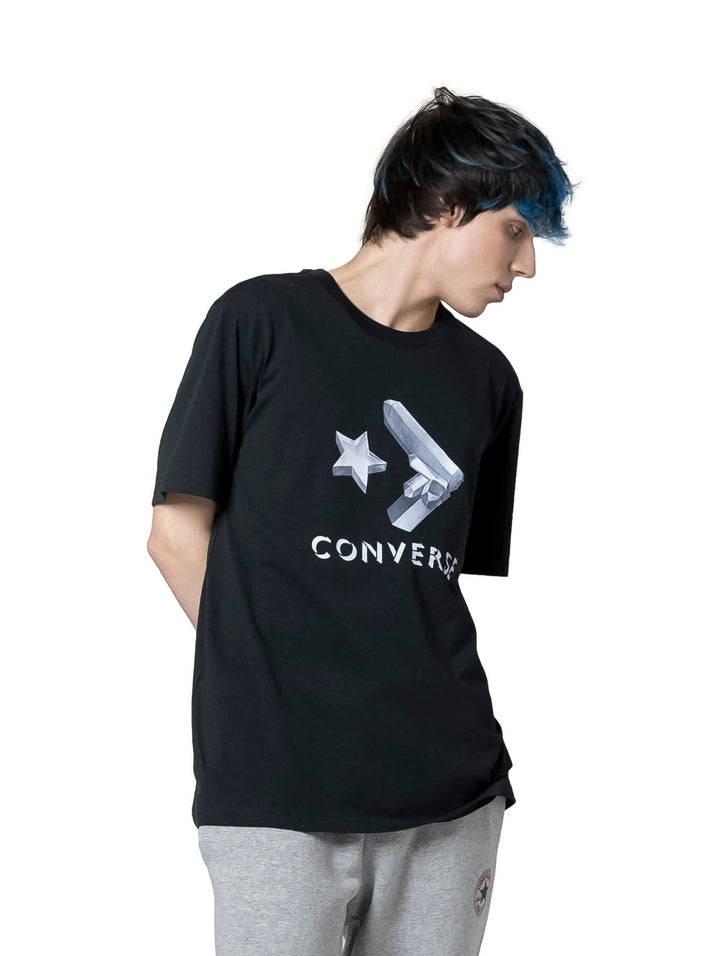 Persona vistiendo una playera negra de manga corta con estampado blanco de la marca Converse.