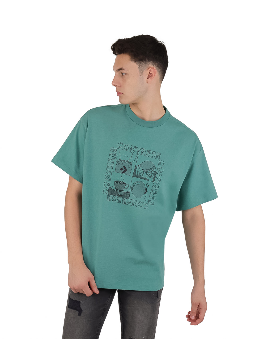 Hombre vistiendo playera Converse color verde azulado con estampado gráfico frontal y manga corta.