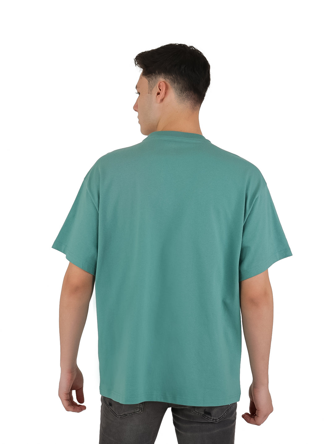 Hombre vistiendo playera Converse color verde azulado con estampado gráfico frontal y manga corta.